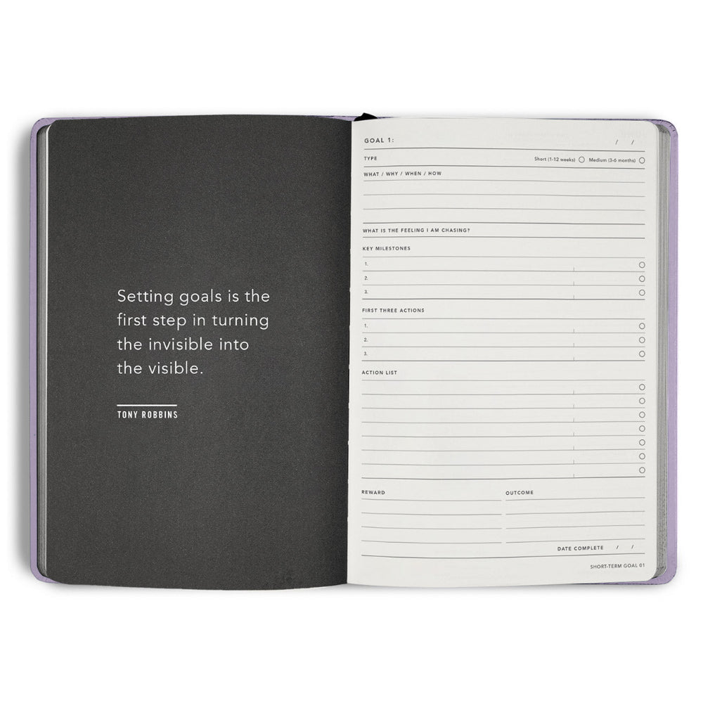 Open planner with goal-setting page and Tony Robbins quote on a white background